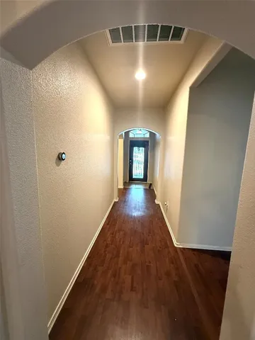 a view of a hallway with wooden floor