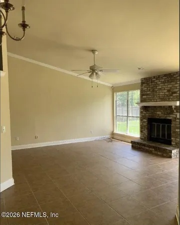 an empty room with windows and fireplace