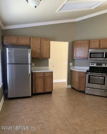 a kitchen with stainless steel appliances a refrigerator a stove a microwave and cabinets