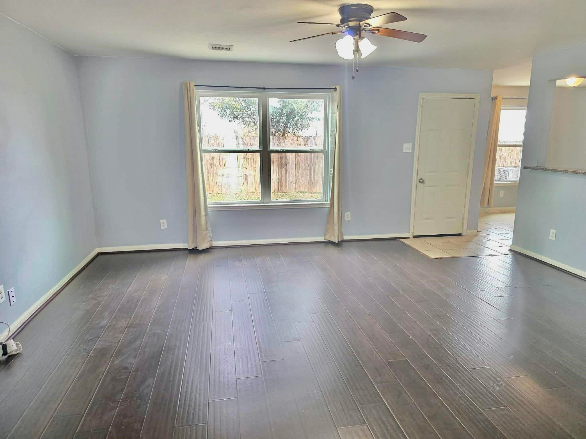 11207 Hall Ridge Court Houston, TX 77075 - Photo 3 of 16 an empty room with wooden floor chandelier fan and windows