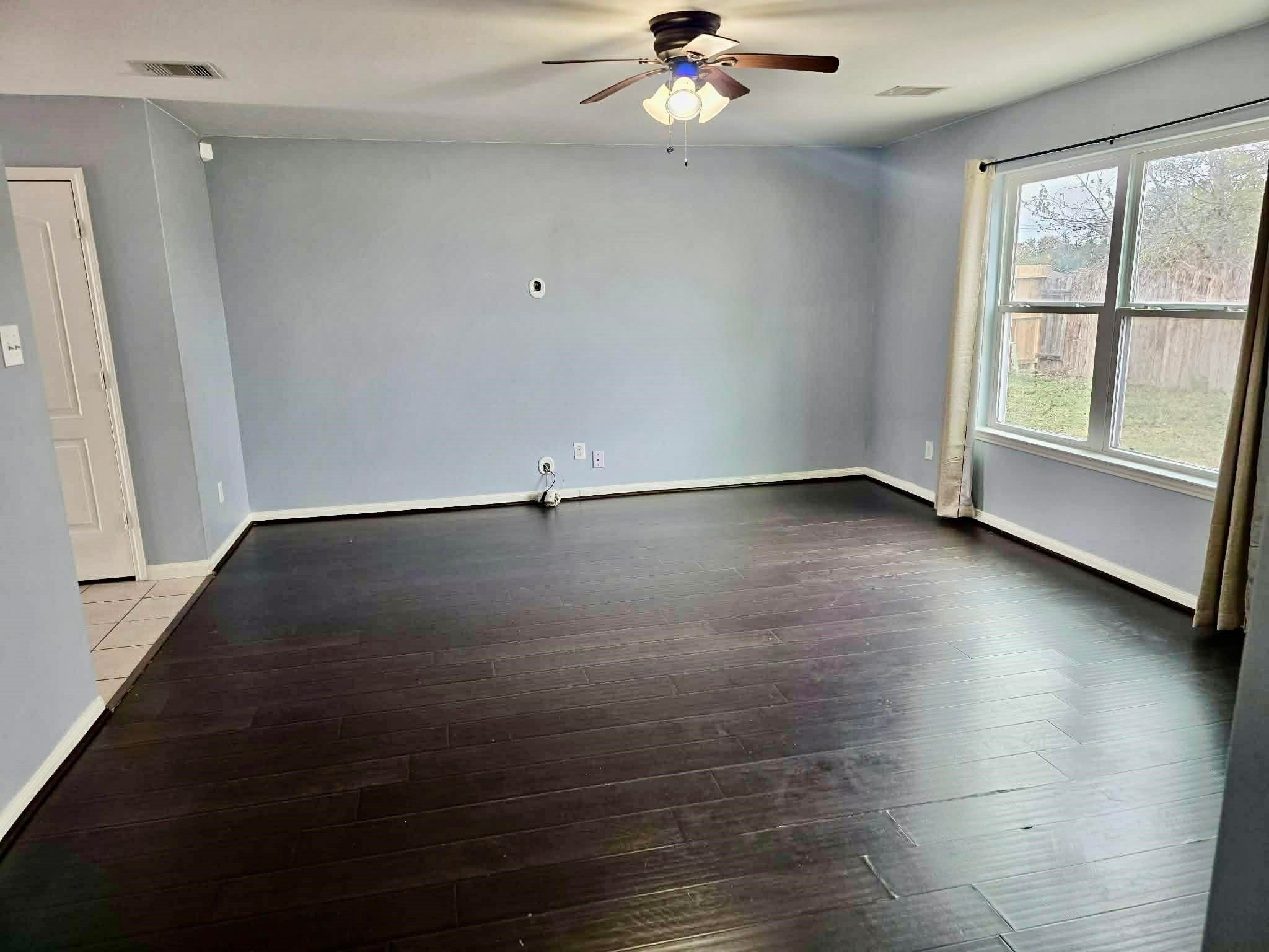 11207 Hall Ridge Court Houston, TX 77075 - Photo 5 of 16 an empty room with wooden floor fan and windows