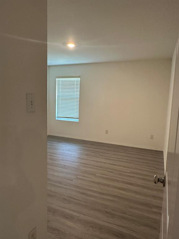 5906 Nyquist Way Forney, TX 75126 - Photo 11 of 27 Empty room featuring wood finished floors and baseboards