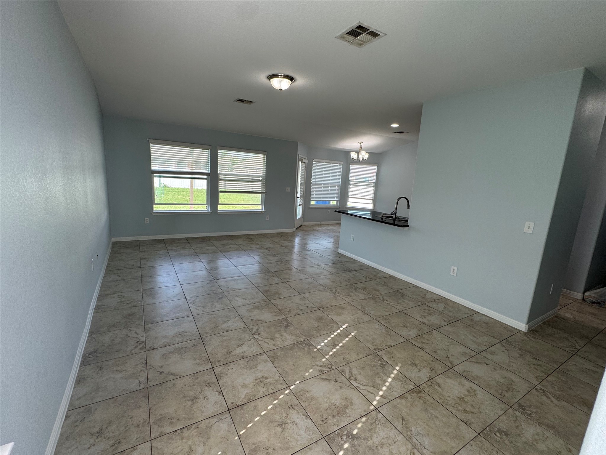 1520 Portchester Castle Path Pflugerville, TX 78660 - Photo 26 of 26 An open floorplan with tiled flooring connects a luminous living space to a functional kitchen area.