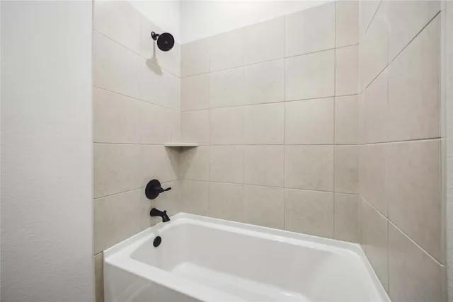 a white bath tub sitting in a bathroom and shower