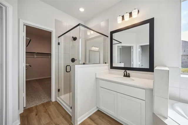 a en suite bathroom with a sink mirror and shower