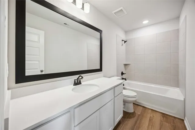 a bathroom with a sink a toilet a mirror and bathtub