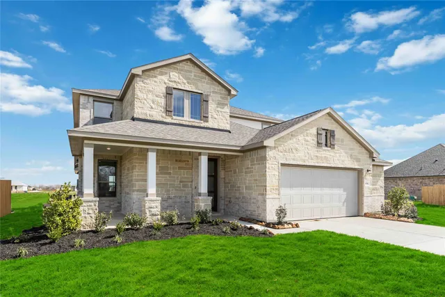 a front view of a house with a garden and yard