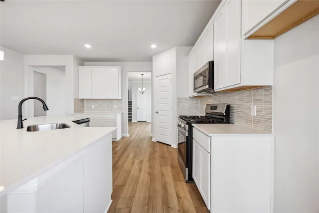 a kitchen with stainless steel appliances granite countertop a stove a sink and a refrigerator