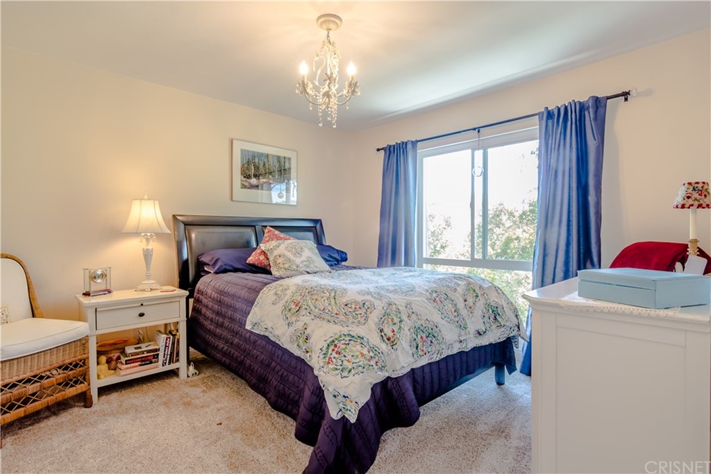 27462 Country Glen Road Agoura Hills, CA 91301 - Photo 12 of 19 a bedroom with a bed and a chandelier