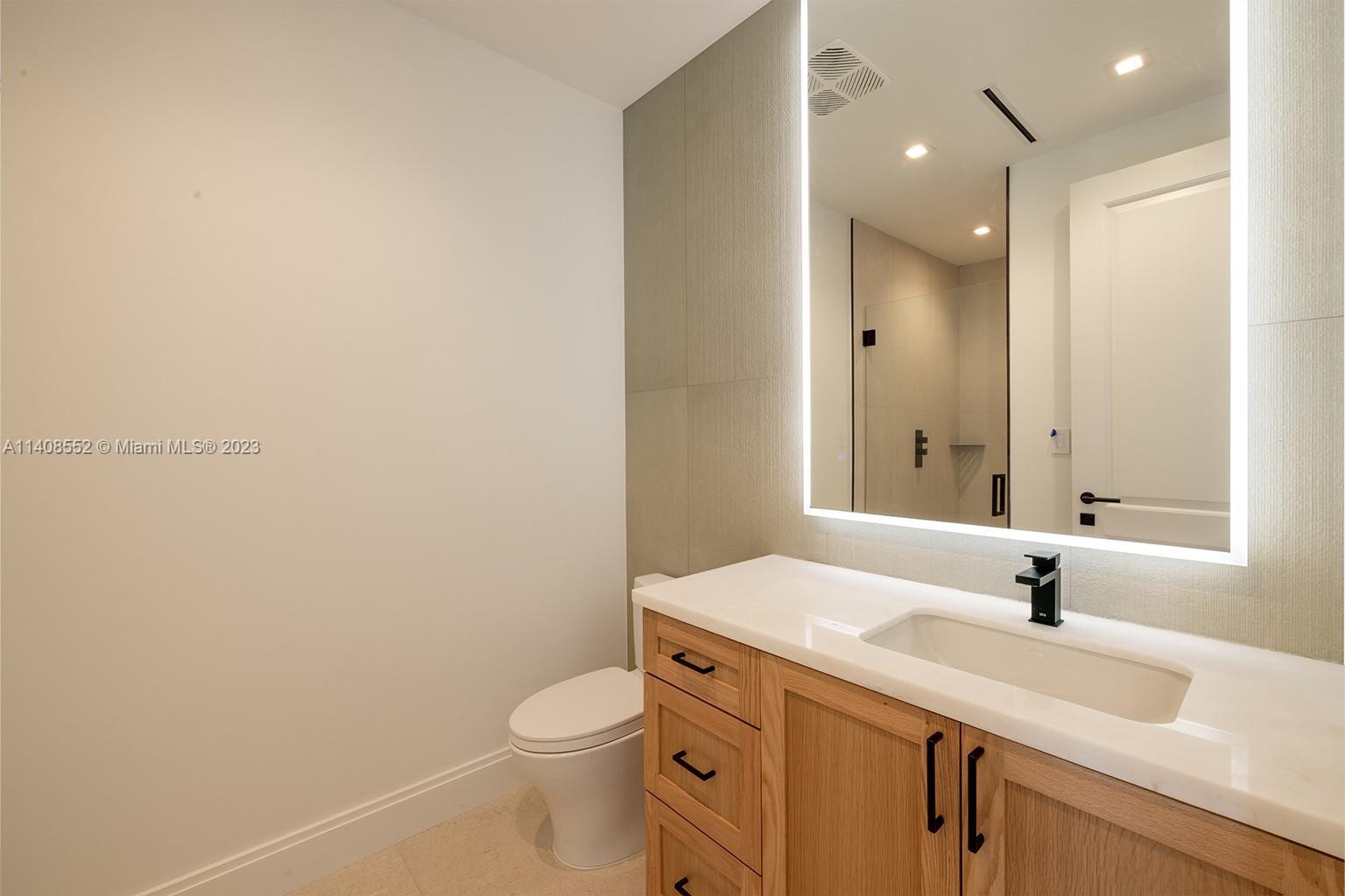 5500 Southwest 74th Street Miami, FL 33143 - Photo 15 of 31 a bathroom with a granite countertop sink a toilet and a mirror