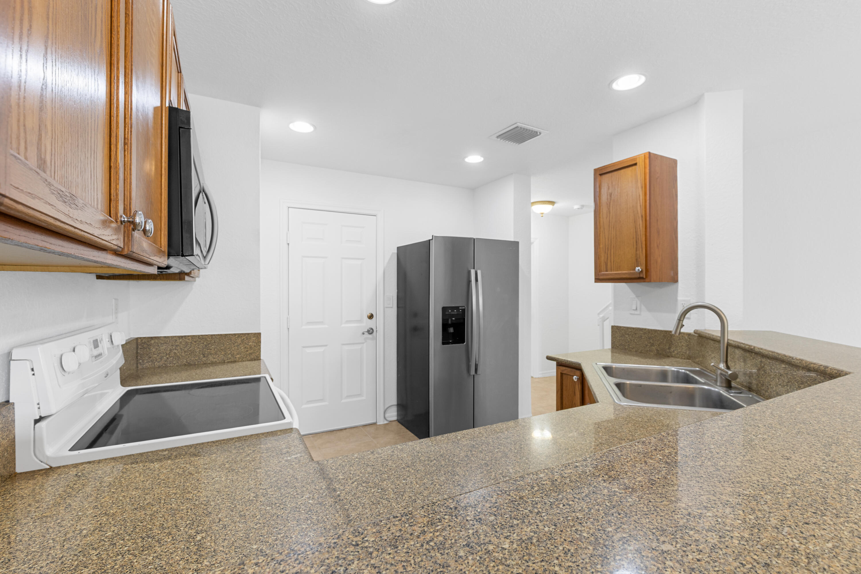 9107 Chambers Street, Unit 9107 Tamarac, FL 33321 - Photo 7 of 30 a kitchen with granite countertop stainless steel appliances a refrigerator and a sink