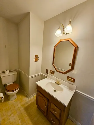 a bathroom with a sink mirror and toilet