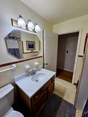 a bathroom with a sink a large mirror and a toilet