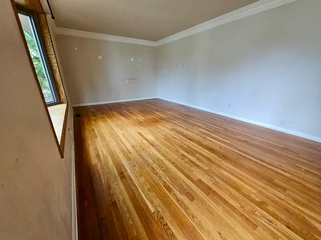a view of empty room with wooden floor