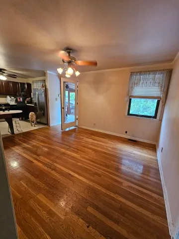 an empty room with windows and ceiling fan