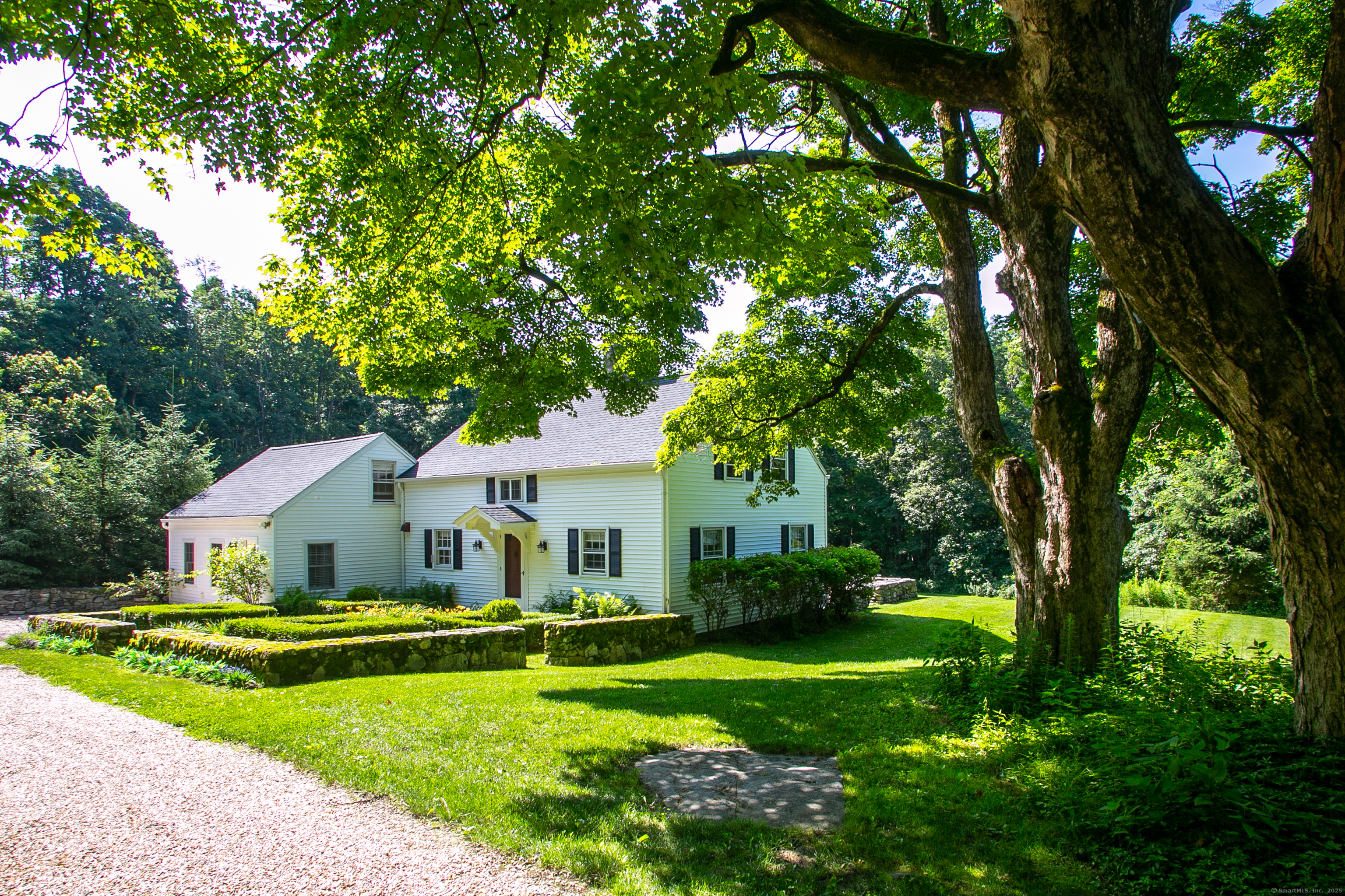 a view of house with garden and trees