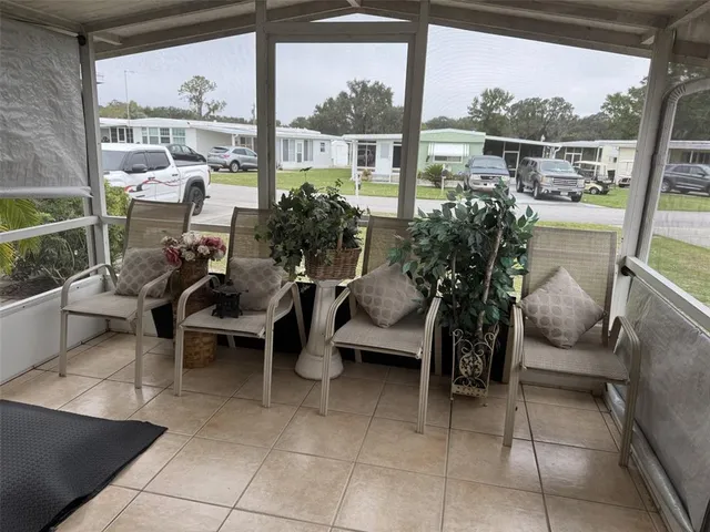 a view of a two chairs and table in the back yard of a house
