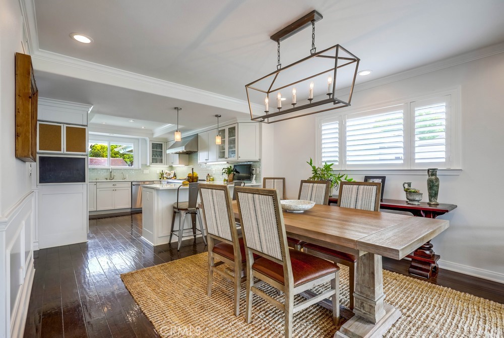 2879 Clubhouse Road Costa Mesa, CA 92626 - Photo 18 of 64 a dining room with stainless steel appliances kitchen island granite countertop a table chairs and a wooden floor