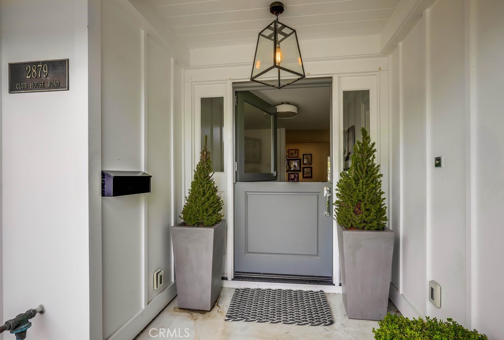 2879 Clubhouse Road Costa Mesa, CA 92626 - Photo 4 of 64 a view of a hallway that has a dining table and a chandelier