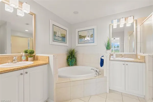 a bathroom with a granite countertop sink a mirror a vanity and a bathtub