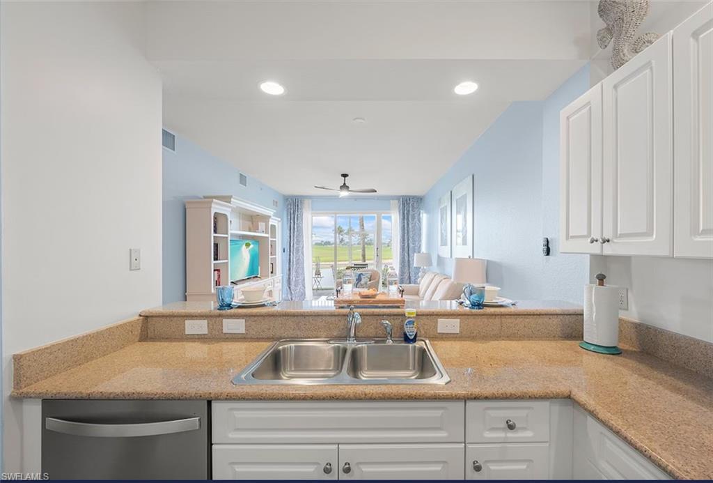 7915 Mahogany Run Lane, Unit 1114 Naples, FL 34113 - Photo 14 of 18 a kitchen with granite countertop a sink and white cabinets