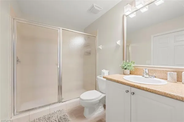 a bathroom with a sink a toilet a mirror and shower
