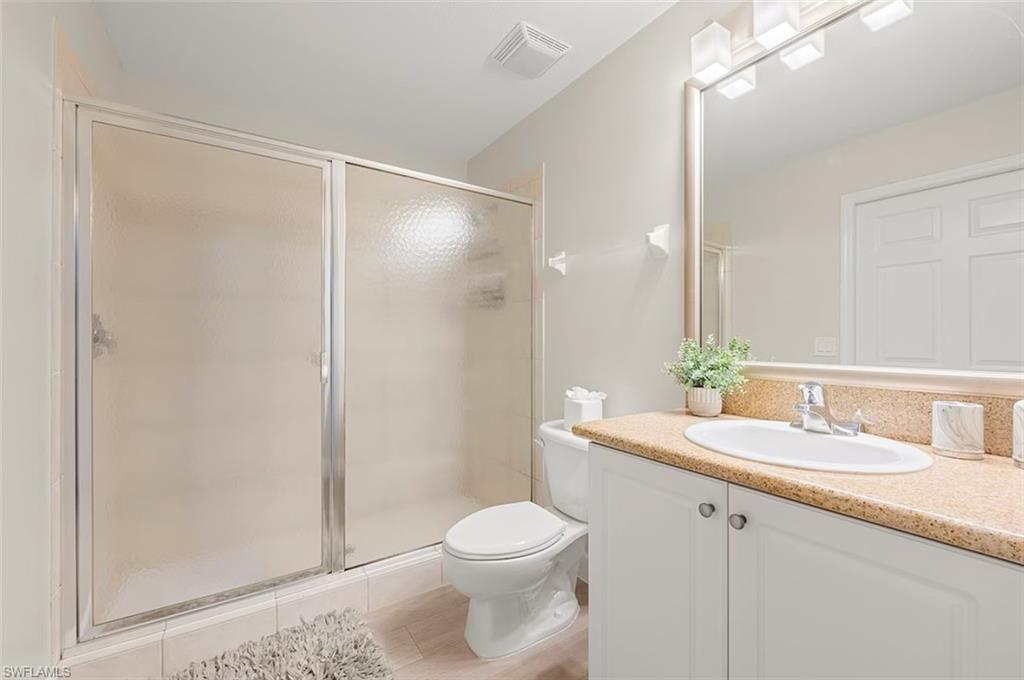 7915 Mahogany Run Lane, Unit 1114 Naples, FL 34113 - Photo 15 of 18 a bathroom with a sink a toilet a mirror and shower