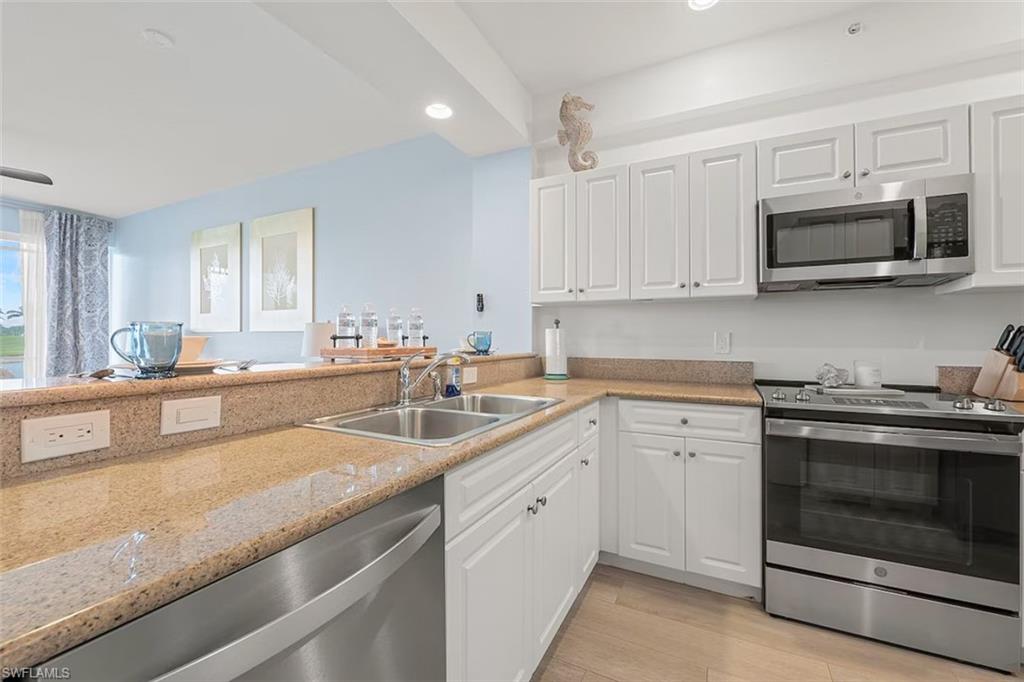 7915 Mahogany Run Lane, Unit 1114 Naples, FL 34113 - Photo 6 of 18 a kitchen with stainless steel appliances granite countertop white cabinets a sink and dishwasher