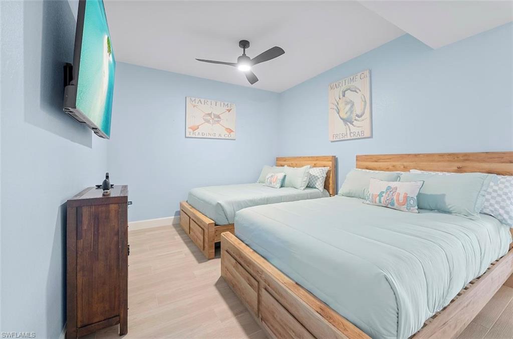 7915 Mahogany Run Lane, Unit 1114 Naples, FL 34113 - Photo 7 of 18 a bedroom with bed and wooden floor