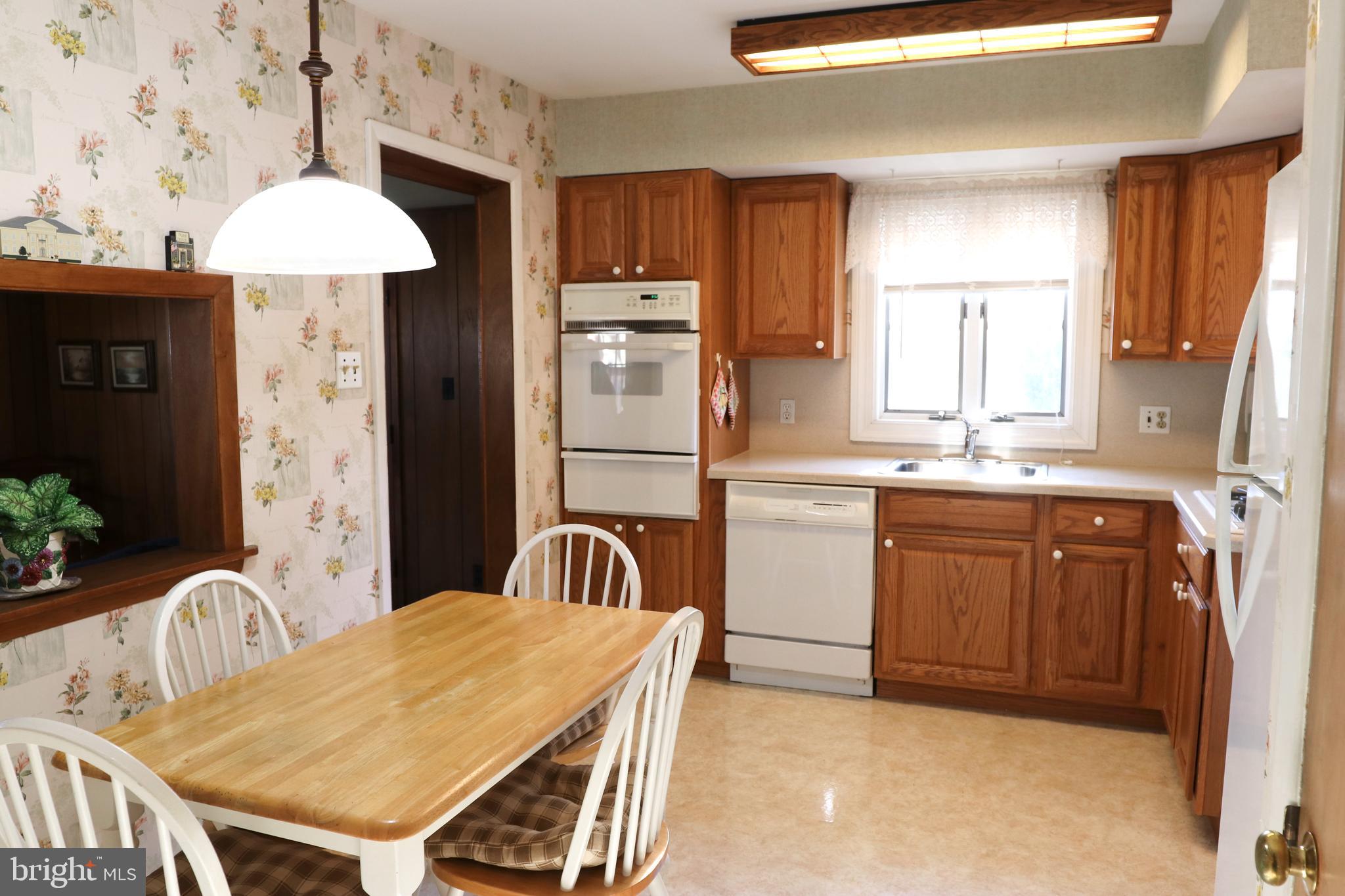 14 Olney Circle Haddonfield, NJ 08033 - Photo 9 of 21 a kitchen with a table chairs a sink a refrigerator and a stove