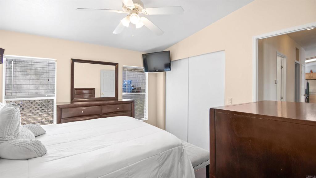 1455 Alturas Road, Unit 55 Fallbrook, CA 92028 - Photo 15 of 31 a bedroom with a large bed and a chandelier