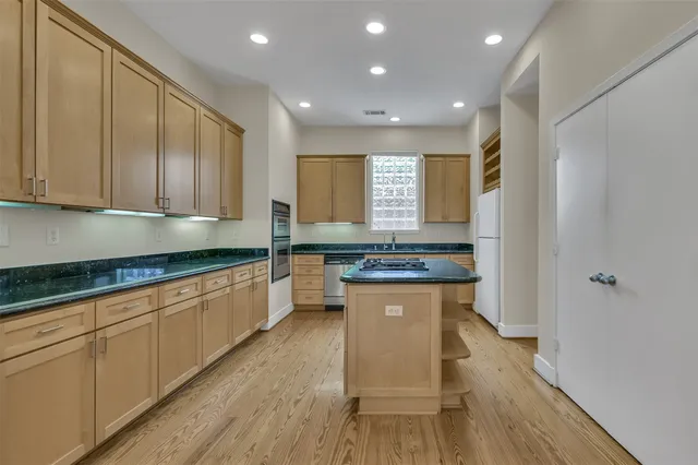 a kitchen with stainless steel appliances granite countertop a stove a sink and a refrigerator