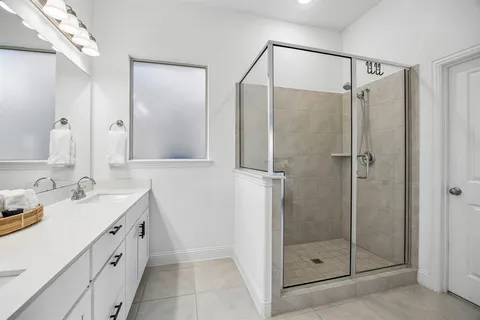 a bathroom with a shower sink and mirror