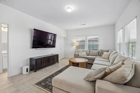 a living room with furniture a flat screen tv and a fireplace