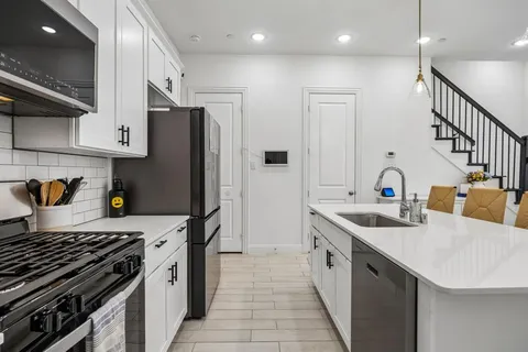 a kitchen with stainless steel appliances granite countertop a sink stove and refrigerator