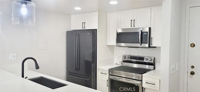 a kitchen with stainless steel appliances granite countertop a refrigerator and a stove top oven