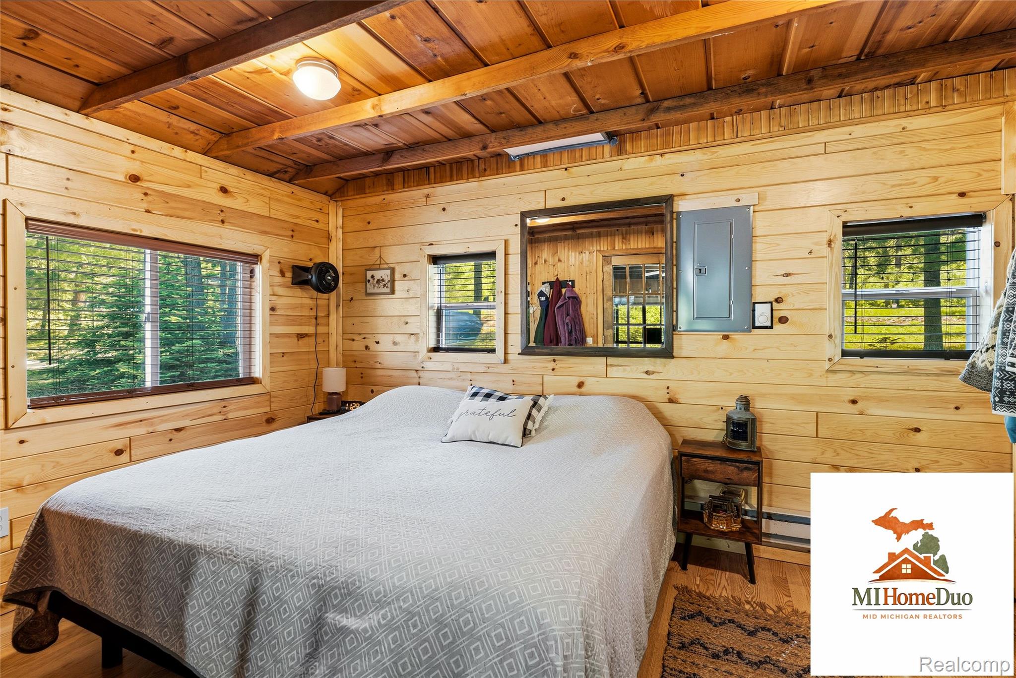 6960 Rumsay Street Harrison, MI 48625 - Photo 26 of 29 Wood-paneled room featuring a wood-finish ceiling, exposed beams, and multiple windows