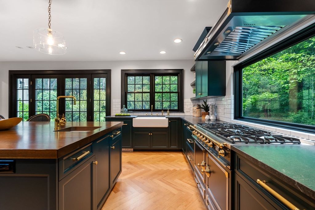 388 Warren Street Brookline, MA 02445 - Photo 12 of 34 a kitchen with stainless steel appliances granite countertop a sink a stove and a wooden floor