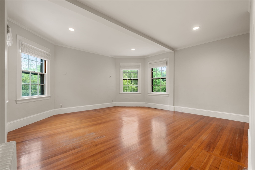 388 Warren Street Brookline, MA 02445 - Photo 19 of 34 an empty room with wooden floor and windows