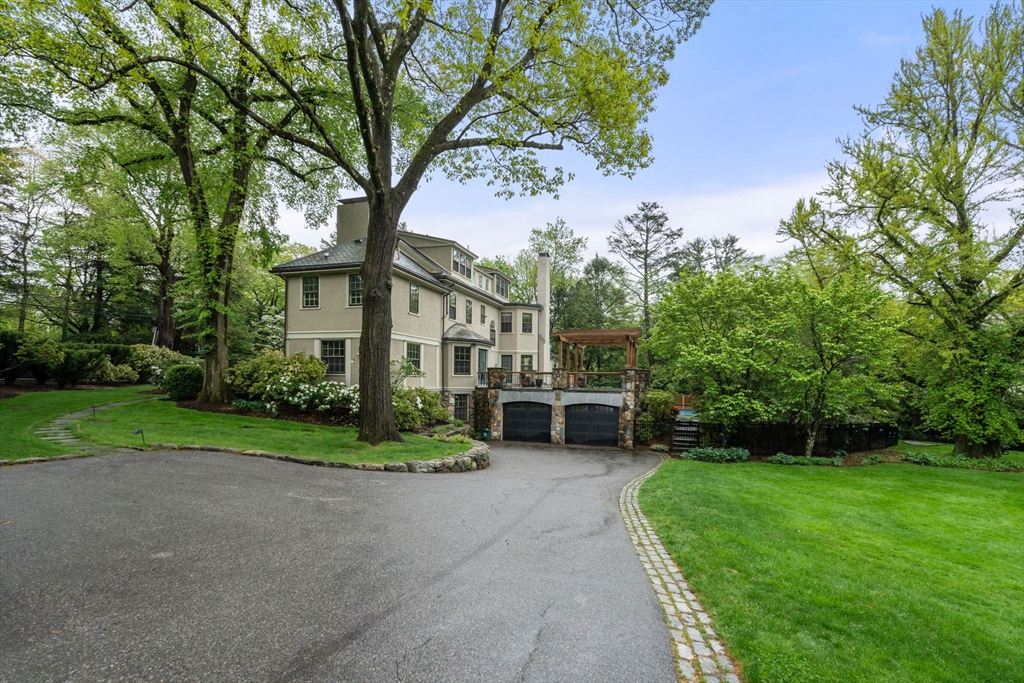 388 Warren Street Brookline, MA 02445 - Photo 2 of 34 a front view of a house with a yard and trees