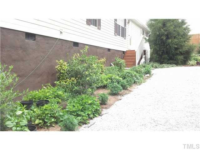 561 George Sherman Road Rougemont, NC 27572 - Photo 21 of 24 Walk way leading to front door, bordered with by flowers and shrubs.