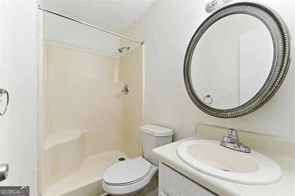 a bathroom with a sink a toilet and a mirror
