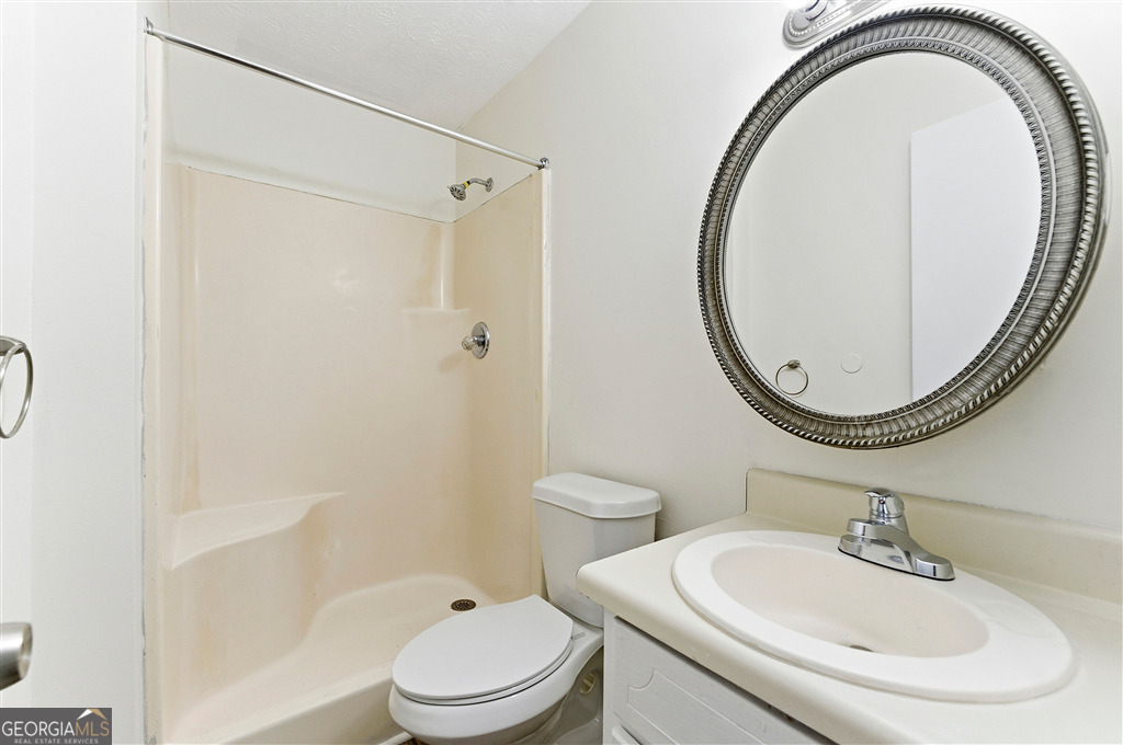 1496 Cherry Hill Road Southwest Conyers, GA 30094 - Photo 11 of 20 a bathroom with a sink a toilet and a mirror