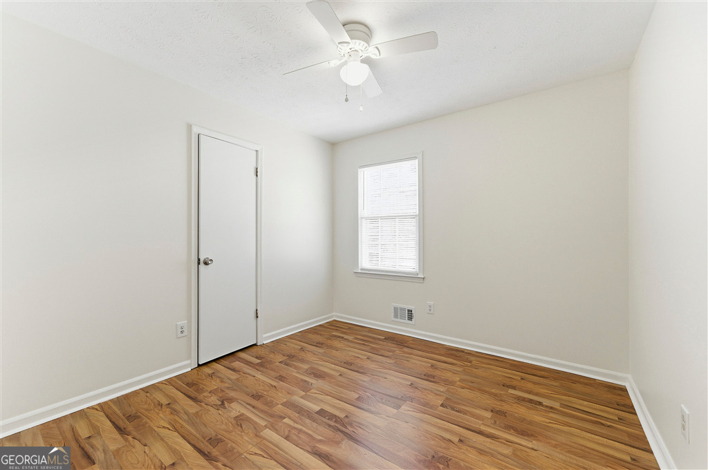 1496 Cherry Hill Road Southwest Conyers, GA 30094 - Photo 12 of 20 wooden floor in an empty room with a window
