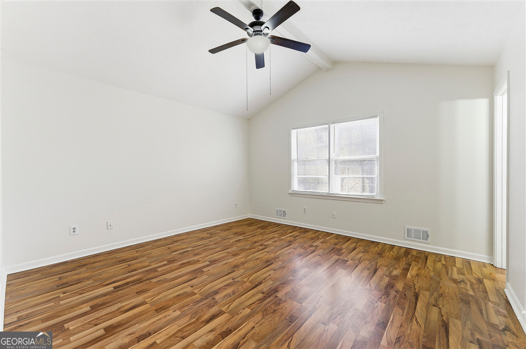 1496 Cherry Hill Road Southwest Conyers, GA 30094 - Photo 14 of 20 an empty room with wooden floor ceiling fan and windows