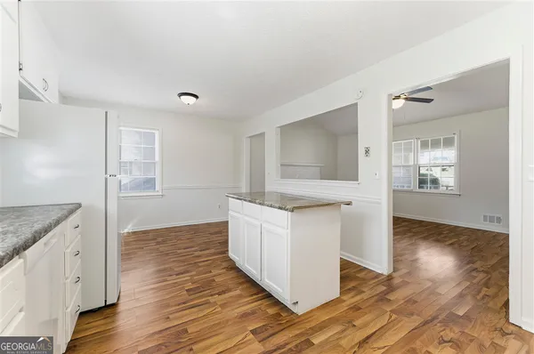 a kitchen with granite countertop white cabinets and white appliances