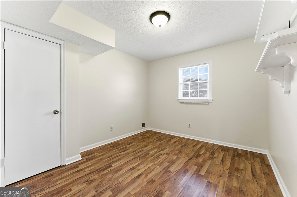 1496 Cherry Hill Road Southwest Conyers, GA 30094 - Photo 10 of 20 an empty room with wooden floor and windows