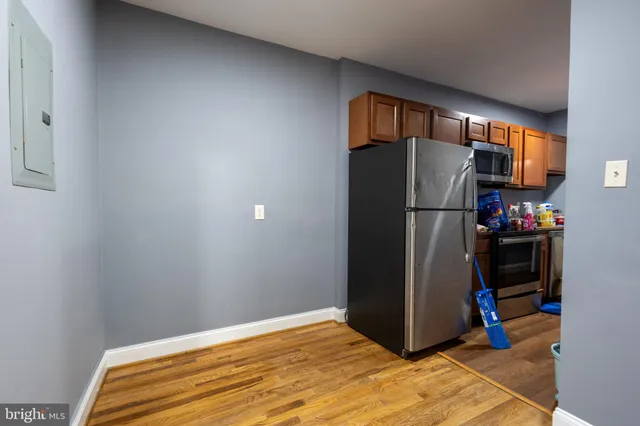 a bedroom with a bed and a refrigerator