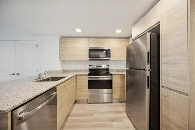 a kitchen with stainless steel appliances granite countertop a refrigerator and a stove