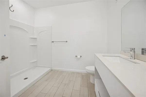 a bathroom with a sink a toilet and shower